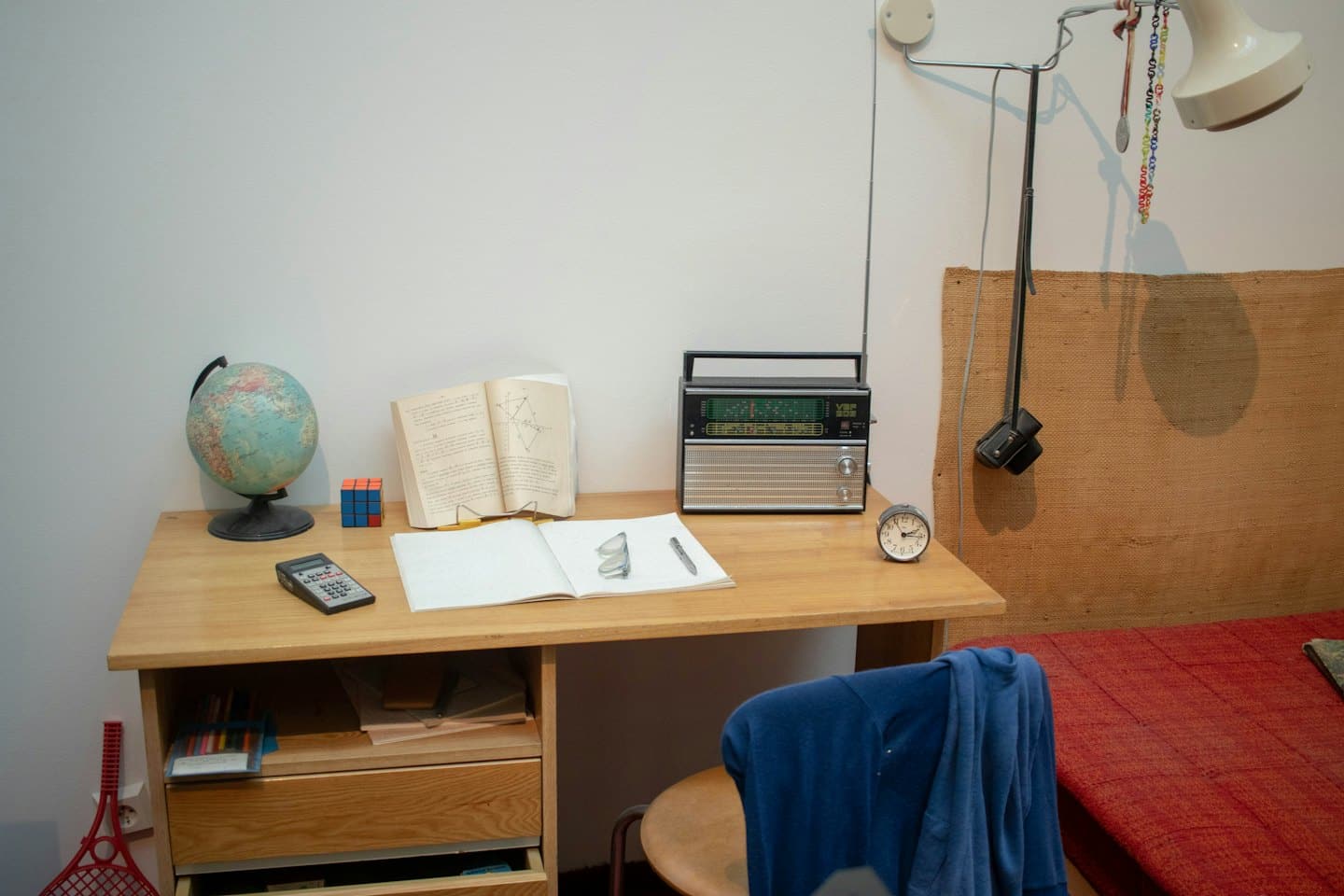 Scrivania da studio con libri e un mappamondo in una camera da letto.